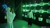 Sejumlah anak muda berpose di tengah instalasi seni cahaya unik yang memenuhi ruang pamer Museum Light Art.