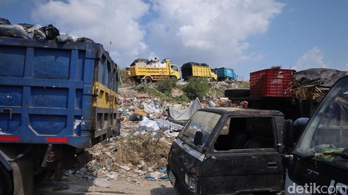 Aktivitas truk pengangkut sampah di TPA Suwung, Jumat (21/8/2025).