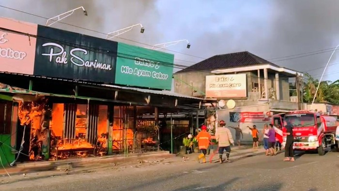 Petugas damkar berusaha memadamkan api yang membakar kios Bakso dan Mie Ayam di Desa Pucung Kidul, Kecamatan Kroya, Kabupaten Cilacap, Sabtu (6/9/2025).