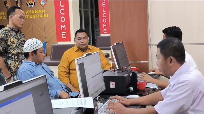 Saat pelapor (peci putih) didampingi kuasa hukumnya (baju kuning) membuat laporan di SPKT Polda Sumsel
