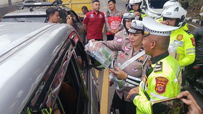 Satlantas Bogor membagikan makanan kepada pengendara yang terjebak one way di Puncak Bogor