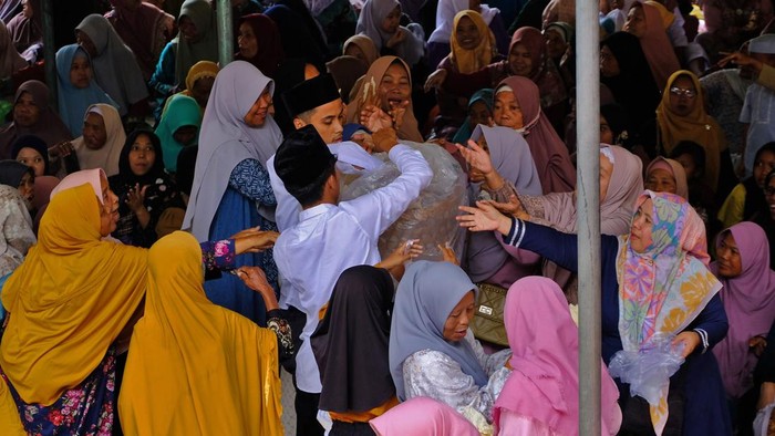 Panitia membagikan Lentheng (ceriping yang terbuat dari beras ketan) saat tradidi Grebeg Lentheng di Sumberarum, Tempuran, Magelang, Jawa Tengah, Sabtu (6/9/2025). Tradisi Grebeg Lentheng dilaksanakan setiap bulan Mulud penanggalan Jawa untuk memperingati maulid Nabi Muhammad SAW sekaligus mengirim doa dan mengenang Kyai Raden Said Abdullah yang diyakini sebagai tokoh penyebar agama Islam di wilayah Magelang. ANTARA FOTO/Anis Efizudin/foc.