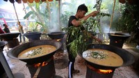1. Warga memasukan bumbu daun temurui ke dalam kuah beulangong atau gulai kari daging di desa Meunasah Gla, kabupaten Aceh Besar, Aceh. Foto: ANTARA FOTO/AMPELSA