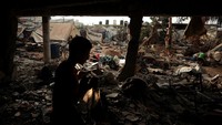 Warga Palestina tampak memeriksa puing-puing bangunan yang rata dengan tanah, mencari barang berharga dan sisa-sisa kehidupan mereka di antara reruntuhan. REUTERS/Dawoud Abu Alkas