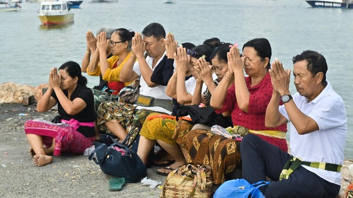 Pemuka agama Hindu menyiramkan air suci saat rangkaian ritual Melukat atau menyucikan diri pada Hari Banyu Pinaruh di Pantai Mertasari, Denpasar, Bali, Minggu (7/9/2025). Ribuan umat Hindu memadati pantai tersebut saat Hari Banyu Pinaruh yang dirayakan satu hari setelah Hari Raya Saraswati untuk menyucikan dan membersihkan diri serta pikiran secara spiritual dengan melakukan ritual Melukat. ANTARA FOTO/Fikri Yusuf