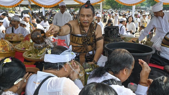 Hari Banyu Pinaruh, Umat Hindu Padati Pantai Mertasari untuk Melukat Pemuka agama Hindu menyiramkan air suci saat rangkaian ritual Melukat atau menyucikan diri pada Hari Banyu Pinaruh di Pantai Mertasari, Denpasar, Bali, Minggu (7/9/2025). Ribuan umat Hindu memadati pantai tersebut saat Hari Banyu Pinaruh yang dirayakan satu hari setelah Hari Raya Saraswati untuk menyucikan dan membersihkan diri serta pikiran secara spiritual dengan melakukan ritual Melukat. ANTARA FOTO/Fikri Yusuf