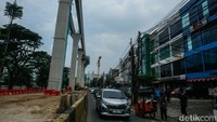 Pengendara melintas di samping proyek LRT Jakarta Fase 1B. Proyek ini menghubungkan Velodrome hingga Manggarai dengan waktu tempuh 28 menit.
