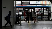 Warga tampak tertib saat mengantre masuk dan keluar bus usai layanan TransJakarta kembali beroperasi 100 persen.  