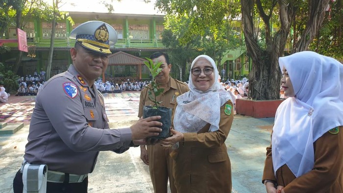 Polantas turun ke SMA di Pekanbaru, Riau mengajak siswa tanam pohon sambil membagikan helm. Dirlantas Polda Riau Kombes Taufiq Lukman Nurhidayat menjadi irup memberikan edukasi kamsetibcarlantas dan pelestarian lingkungan hidup, Senin (8/9/2025).