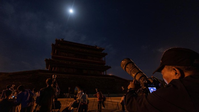 Photographers take images of a full moon over Yongdingmen Gate before a a total lunar eclipse in Beijing, China, September 8, 2025. REUTERS/Maxim Shemetov