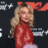 Rambut pirangnya dibiarkan terurai bergelombang, menambah kesan glamor, sementara riasan wajahnya terlihat segar dengan sentuhan glowy khas dirinya.  Foto: Getty Images/Dimitrios Kambouris