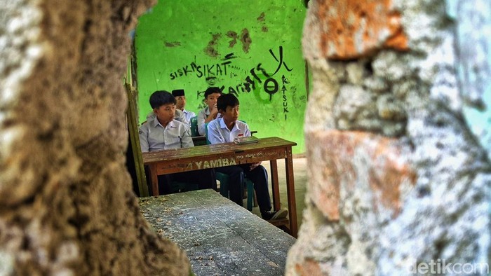 Siswa MTs Miftahul Barokah belajar di ruang kelas dengan lantai retak dan dinding penuh coretan di Kampung Gempol, Desa Cikadu, Kecamatan Palabuhanratu, Senin (8/9/2025).