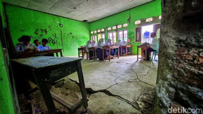 Siswa MTs Miftahul Barokah belajar di ruang kelas dengan lantai retak dan dinding penuh coretan di Kampung Gempol, Desa Cikadu, Kecamatan Palabuhanratu, Senin (8/9/2025).