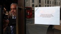Sebuah tanda terpampang di pintu sebuah toko Armani saat seorang staf menutupnya pada hari pemakaman perancang busana Italia Giorgio Armani, di Regent Street, London, Inggris. REUTERS/Toby Melville