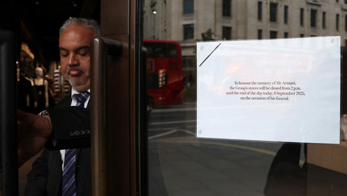 A sign is displayed on the door of an Armani shop as a staff member closes it on the day of the funeral ceremony for Italian fashion designer Giorgio Armani, in Regent Street, London, Britain, September 8, 2025. REUTERS/Toby Melville