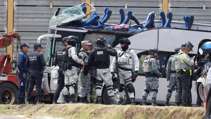National Guard members and army soldiers arrive at the scene of an accident involving a passenger bus and a train in Atlacomulco, Mexico State, on September 8, 2025. According to the State of Mexico attorney general office, seven women and three men were killed in the accident. (Photo by Ramses VLADES / AFP)