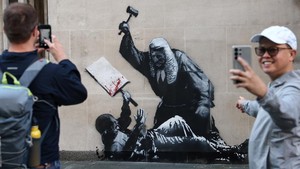 Awal pekan ini, Banksy membuat mural seorang hakim mengenakan jas kebesarannya tengah memukul demonstran pakai palu. Mural ini menyoroti peristiwa 900 orang demonstran pro-Palestina yang baru saja ditangkap.Foto: REUTERS/Toby Melville