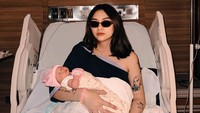 Pose Beby memakai kacamata sambil menggendong Janeera. Penampilan Beby mendapat pujian dari netizen karena tetap keren usai melahirkan. Foto: Instagram @onadioleonardo_official