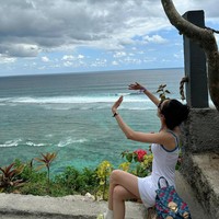 Meski tak berenang di pantai, aura bahagia Sandara Park terpancar dari wajahnya saat melihat keindahan Pantai Pandawa dari atas tebing. Ia pun sempat salah fokus dengan seorang turis yang tampak terbang, melakukan paragliding. Foto: dok. Instagram @daraxxi