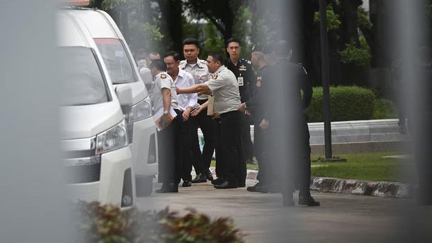 Former Thai Prime Minister Thaksin Shinawatra is escorted by corrections officers after the supreme court ruled to return Thaksin to prison for one year, in the case of his unlawful six-month hospital stay before he was granted parole, in Bangkok, Thailand, September 9, 2025. REUTERS/Panumas Sanguanwong Purchase Licensing Rights
