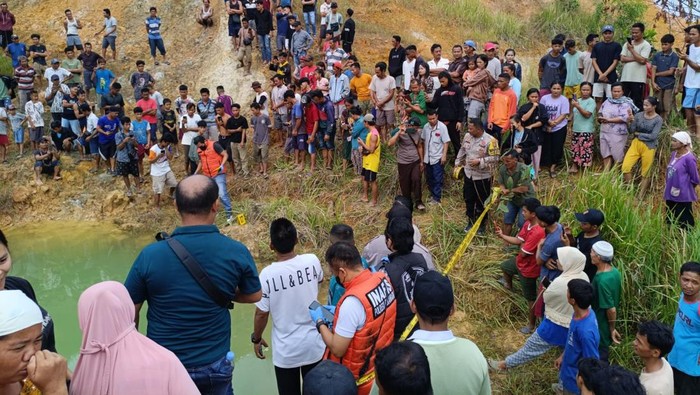 Warga berkerumun di lokasi dua bocah tenggelam, di kolam bekas galian di Pekanbaru, Riau, Selasa (9/9/2025).