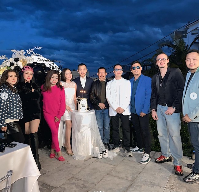 Kenakan mini dress berwarna putih, Angel tampil cantik dengan riasan natural dan rambut yang dibiarkan terurai. Ia tampak berpose bersama para sahabat Gusti Ega yang turut hadir. Foto: Instagram/@gustiega/@realangelkaramoy/@lndjalil