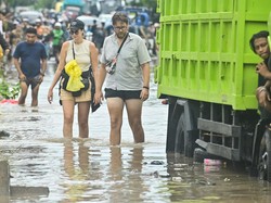 Beberapa turis asing menerobos banjir yang menggenangi kawasan Kuta, Badung, Bali, Rabu. Ketinggian air di kawasan pariwisata itu mencapai 1,5 meter. (Foto: ANTARA FOTO/Fikri Yusuf)