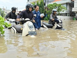 Banjir juga menggenangi sejumlah ruas jalan di kawasan Kuta, Badung, Bali, Rabu. Sejumlah warga yang melintas terpaksa mendorong sepeda motor melewati banjir di ruas jalan tersebut. (Foto: ANTARA FOTO/FIKRI YUSUF)