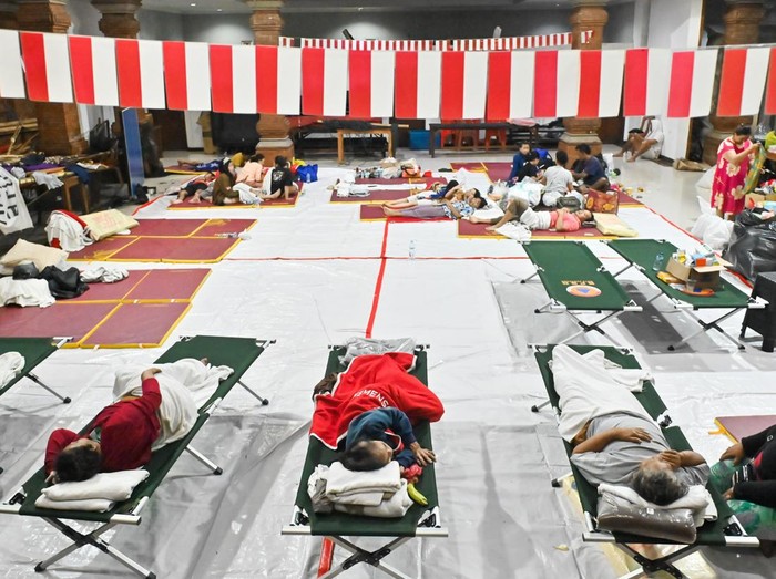 Warga menghubungi keluarganya di posko pengungsian bencana banjir di kawasan Denpasar Timur, Denpasar, Bali, Rabu (10/9/2025). Sekitar 80 orang warga di kawasan tersebut mengungsi di dua titik pengungsian akibat tempat tinggalnya rusak diterjang banjir. ANTARA FOTO/Fikri Yusuf/nz