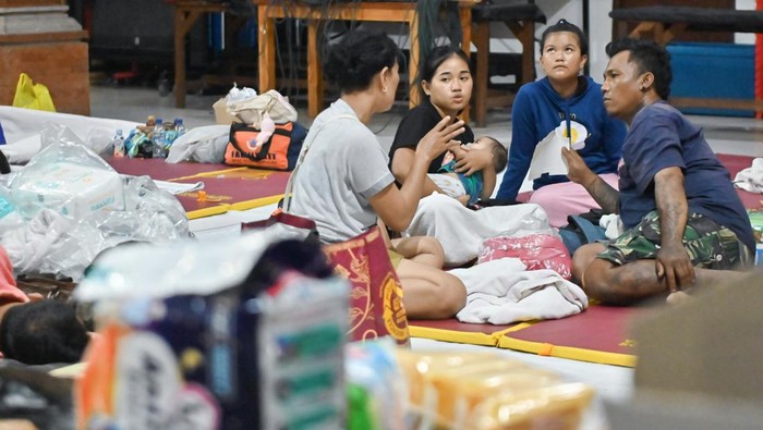 Warga menghubungi keluarganya di posko pengungsian bencana banjir di kawasan Denpasar Timur, Denpasar, Bali, Rabu (10/9/2025). Sekitar 80 orang warga di kawasan tersebut mengungsi di dua titik pengungsian akibat tempat tinggalnya rusak diterjang banjir. ANTARA FOTO/Fikri Yusuf/nz