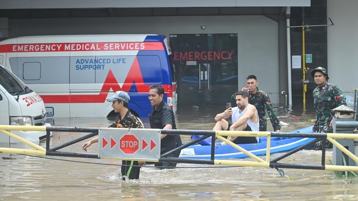 Petugas mengevakuasi wisatawan mancanegara yang terjebak banjir di kawasan Kuta, Badung, Bali, Rabu (10/9/2025). Sejumlah wisatawan mancanegara dievakuasi petugas dari sejumlah lokasi di kawasan pariwisata itu karena terendam banjir yang disebabkan hujan yang mengguyur wilayah Bali sejak Selasa (9/9). ANTARA FOTO/Fikri Yusuf/nym.