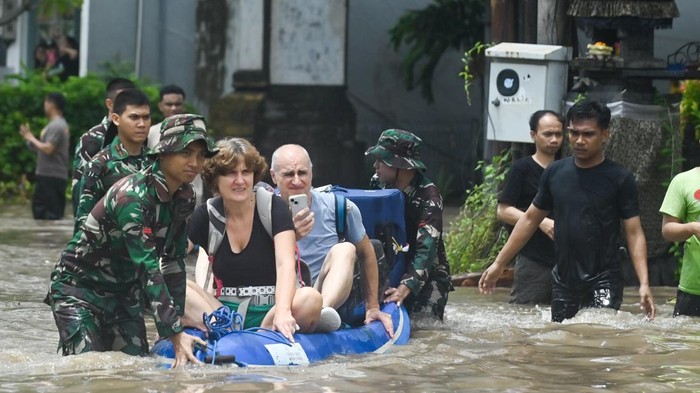 Petugas mengevakuasi wisatawan mancanegara yang terjebak banjir di kawasan Kuta, Badung, Bali, Rabu (10/9/2025). Sejumlah wisatawan mancanegara dievakuasi petugas dari sejumlah lokasi di kawasan pariwisata itu karena terendam banjir yang disebabkan hujan yang mengguyur wilayah Bali sejak Selasa (9/9). ANTARA FOTO/Fikri Yusuf/nym.