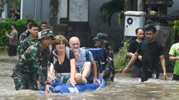 Petugas mengevakuasi wisatawan mancanegara yang terjebak banjir di kawasan Kuta, Badung, Bali, Rabu (10/9/2025). Sejumlah wisatawan mancanegara dievakuasi petugas dari sejumlah lokasi di kawasan pariwisata itu karena terendam banjir yang disebabkan hujan yang mengguyur wilayah Bali sejak Selasa (9/9). ANTARA FOTO/Fikri Yusuf/nym.