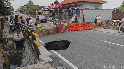 Lubang menganga akibat tergerus hujan deras di Jalan Raya Lukluk di Kelurahan Lukluk, Kecamatan Mengwi, Badung, Bali, Rabu (10/9/2025). (Foto: Agus Eka/detikBali)