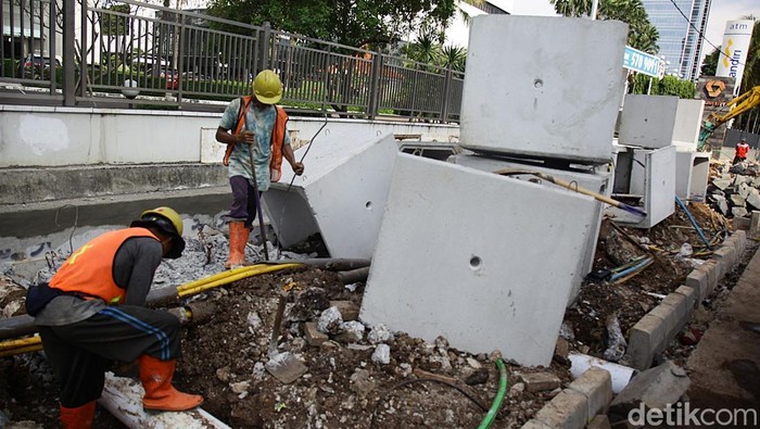 Pekerja mengerjakan proyek jalur pedestrian sekaligus saluran air di perempatan Jalan S. Parman dan Jalan KS Tubun, Slipi, Jakarta Barat, Rabu (10/10/2025).