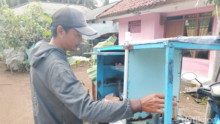 Reza saat berjualan kue putu.