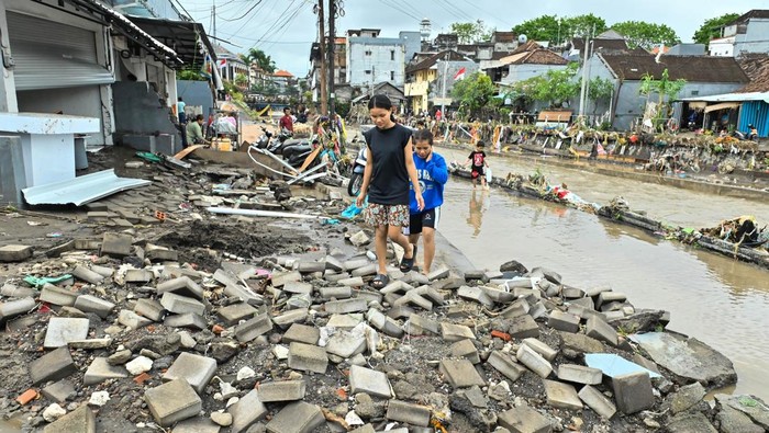 Warga mengamati kondisi bangunan ruko yang hancur diterjang banjir di kawasan Jalan Sulawesi, Denpasar, Bali, Rabu (10/9/2025). Sejumlah bangunan seperti ruko, toko dan rumah warga di wilayah Denpasar mengalami kerusakan akibat banjir yang terjadi di sejumlah titik sejak Rabu pagi. ANTARA FOTO/Fikri Yusuf/nz