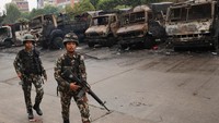 Tentara Nepal berjalan melewati kendaraan yang terbakar di dalam kompleks Parlemen. Para demonstran membakar gedung Dewan Perwakilan Rakyat, markas besar Partai Kongres Nepal, dan rumah mantan perdana menteri Sher Bahadur Deuba. Rumah beberapa politisi lainnya juga telah dirusak. REUTERS/Adnan Abidi