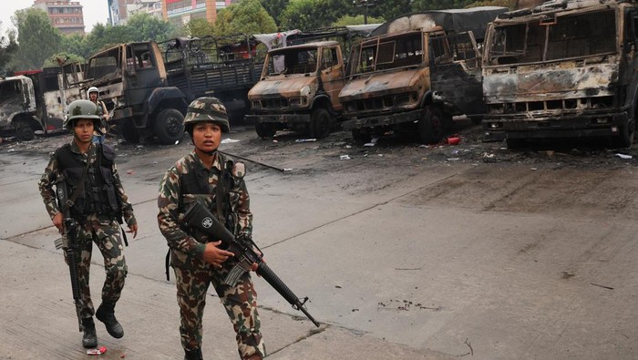 A Nepali army soldier walks in front of the Parliament house which was set on fire by the protesters, following Mondays killing of 19 people after anti-corruption protests that were triggered by a social media ban, which was later lifted, in Kathmandu, Nepal, September 10, 2025. REUTERS/Adnan Abidi