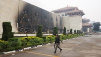 Seorang tentara Nepal berjalan di depan Gedung Parlemen yang dibakar oleh para pengunjuk rasa di Kathmandu, Nepal, Rabu (10/9/2025). Demo dilatarbelakangi protes antikorupsi yang dipicu oleh larangan media sosial, yang kemudian dicabut. REUTERS/Adnan Abidi