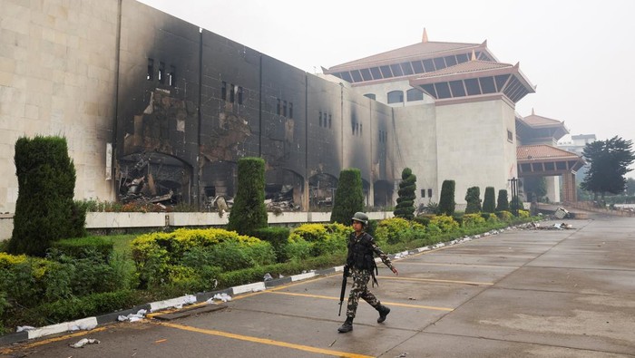 A Nepali army soldier walks in front of the Parliament house which was set on fire by the protesters, following Monday's killing of 19 people after anti-corruption protests that were triggered by a social media ban, which was later lifted, in Kathmandu, Nepal, September 10, 2025. REUTERS/Adnan Abidi