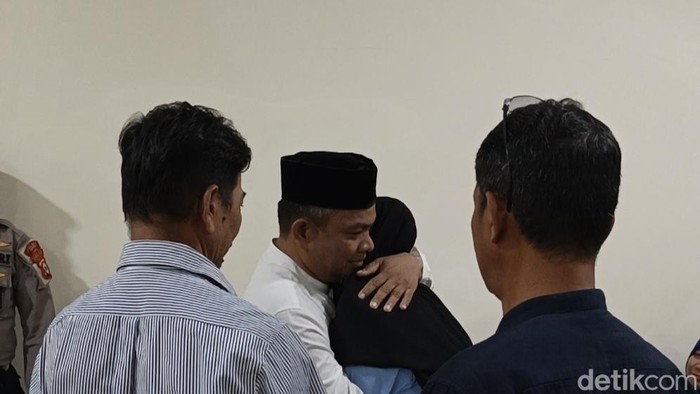 Terdakwa Ambo Ala memeluk istrinya usai divonis 4 tahun penjara di kasus uang palsu.