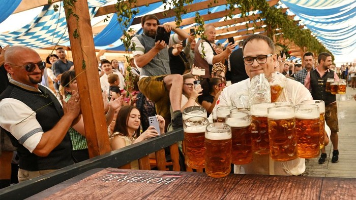 Oliver Strumpfel attempts to break the world record for beer-mug carrying with 31 mugs, but he drops some mugs along the way, at the Hofbrauzelt tent in Gillamoos festival, in Abensberg, Germany, September 7, 2025. REUTERS/Angelika Warmuth     TPX IMAGES OF THE DAY