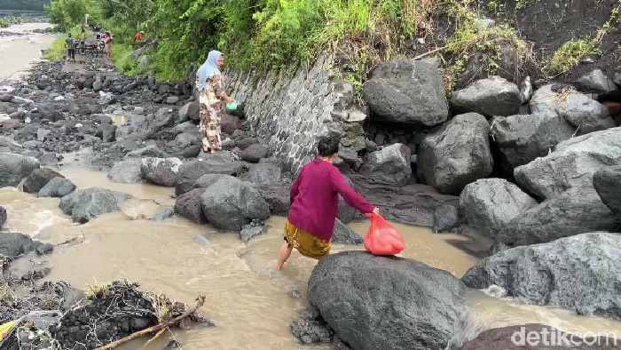 Warga di Lumajang harus melewati sungai gegara jembatan ambrol