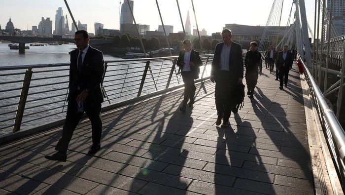 Workers walk across the Golden Jubilee Bridges during the morning rush hour as London Tube rail strikes continue, in London, Britain, September 8, 2025. REUTERS/Toby Melville