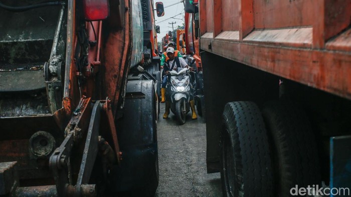 Pengendara motor membalap truk sampah di Jalan Pangkalan 5, Bantargebang, Bekasi, Kamis (11/9/2025).