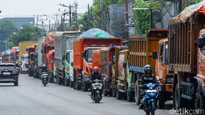 Pengendara motor membalap truk sampah di Jalan Pangkalan 5, Bantargebang, Bekasi, Kamis (11/9/2025).