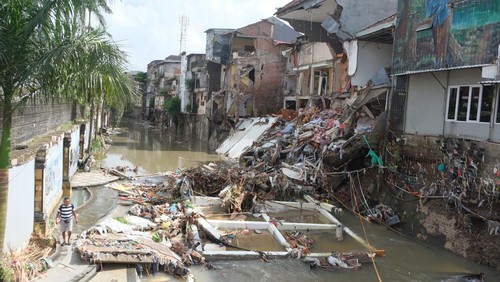 Warga berjalan melewati lumpur pasca terjadi banjir di Pasar Kumbasari, Denpasar, Bali, Kamis (11/9/2025). Badan Penanggulangan Bencana Daerah (BPBD) Provinsi Bali mencatat lebih dari 120 titik banjir yang menerjang tujuh wilayah administrasi kabupaten dan kota di Bali dan data sementara per Kamis (11/9), total korban meninggal dunia yang sudah ditemukan berjumlah 14 orang dan yang masih dalam pencarian sebanyak dua orang. ANTARA FOTO/Nyoman Hendra Wibowo