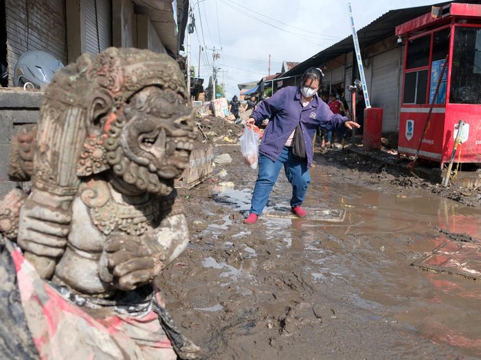 Warga berjalan melewati lumpur pasca terjadi banjir di Pasar Kumbasari, Denpasar, Bali, Kamis (11/9/2025). Badan Penanggulangan Bencana Daerah (BPBD) Provinsi Bali mencatat lebih dari 120 titik banjir yang menerjang tujuh wilayah administrasi kabupaten dan kota di Bali dan data sementara per Kamis (11/9), total korban meninggal dunia yang sudah ditemukan berjumlah 14 orang dan yang masih dalam pencarian sebanyak dua orang. ANTARA FOTO/Nyoman Hendra Wibowo