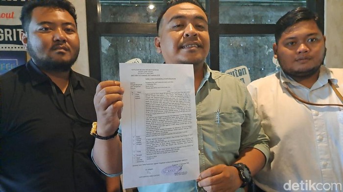Kuasa hukum pengelola SPBU Losari, Esa Caesar Farandi (tengah) menunjukkan laporan polisi atas tuduhan pencemaran nama baik dan penyebaran berita bohong soal konten BBM campur air, Kamis (11/9/2025).
